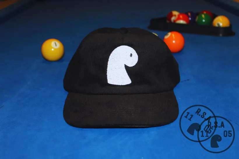 Black corduroy cap with white embroidered EMVŸ mark