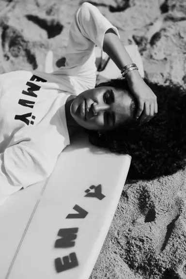 Earthian lying on the sand in an EMVŸ tee, black and white