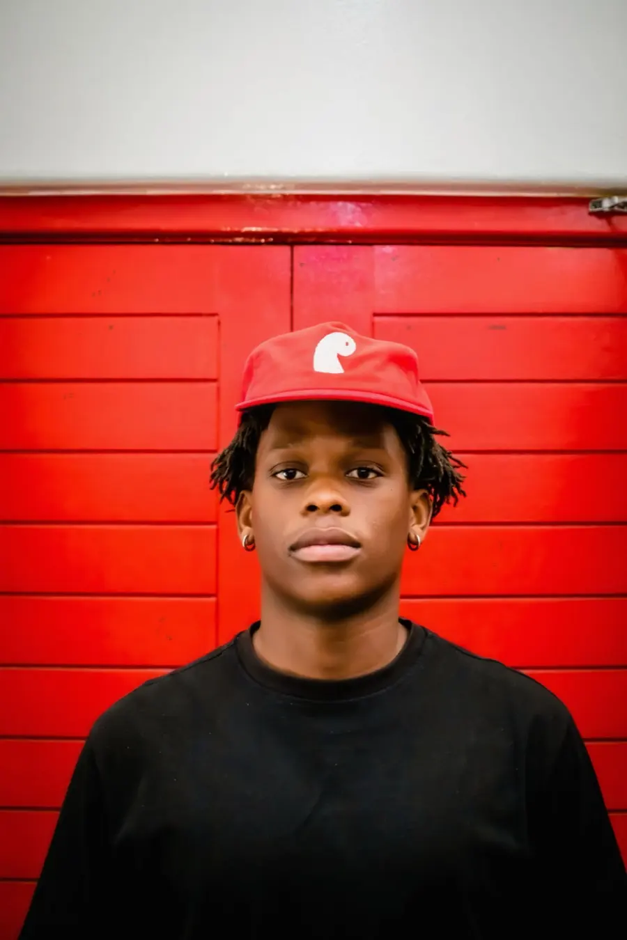 Earthian wearing the red corduroy EMVŸ cap
