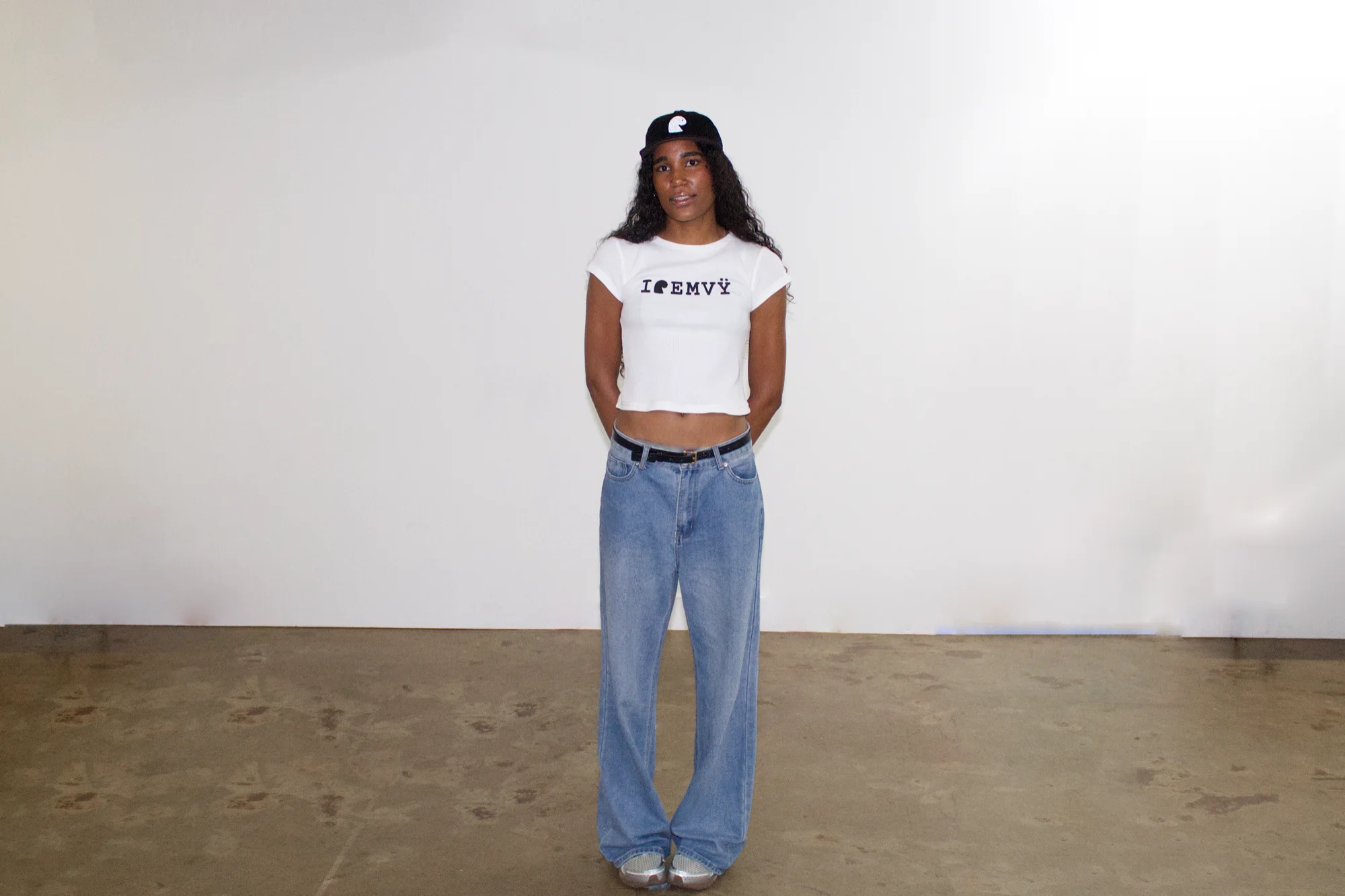 White waffle I love EMVŸ baby tee full length, worn with a black EMVŸ cap