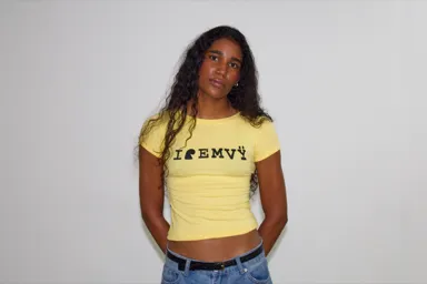 Yellow I love EMVŸ baby tee worn front-on