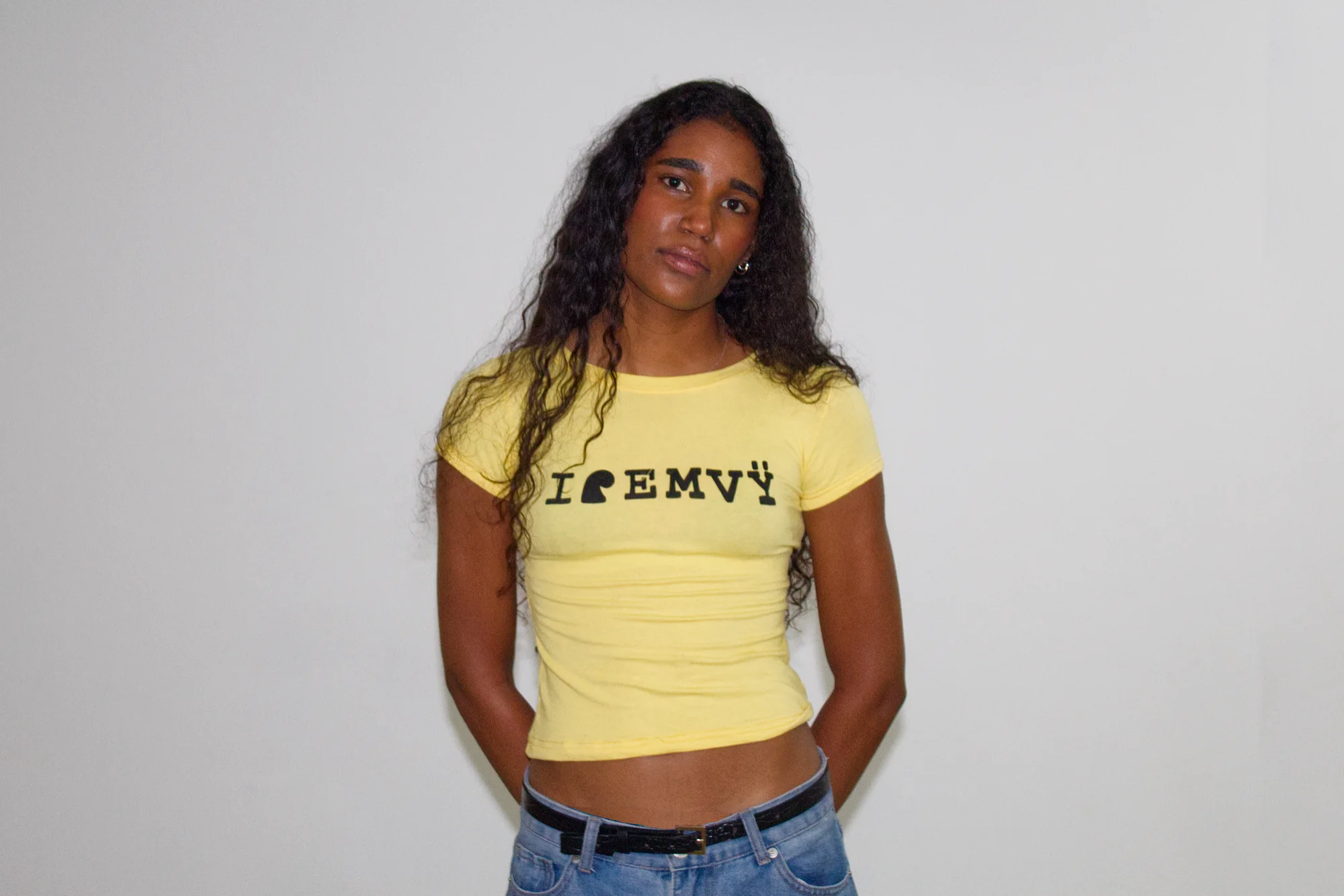 Yellow I love EMVŸ baby tee worn front-on