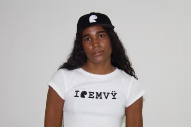 Black corduroy cap with the white embroidered EMVŸ mark, worn front-on