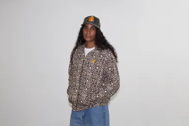 Leopard-print EMVŸ cheater hoodie zipped up, worn front-on with the camo cap